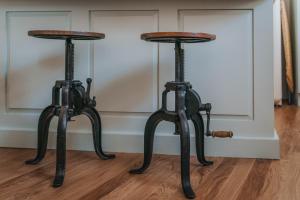 a pair of metal stools sitting on a wooden floor at The Burrow Escape in Branston
