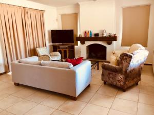 sala de estar con 2 sofás y chimenea en La Guarida de Chacras en Luján de Cuyo