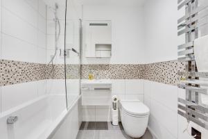 uma casa de banho branca com um WC e um chuveiro em Executive 2 BR apt city centre free PKG , wifi by Tent Serviced Apartments em Staines