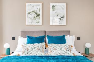 1 dormitorio con 1 cama con almohadas azules y blancas en Executive 2 BR apt city centre free PKG , wifi by Tent Serviced Apartments en Staines