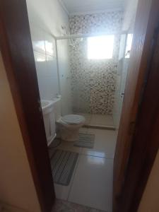 a small bathroom with a toilet and a shower at Jockey Apto 2 in Campos dos Goytacazes