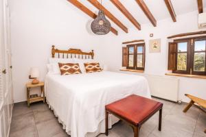 Schlafzimmer mit einem Bett, einem Stuhl und Fenstern in der Unterkunft Casa Del Maco in Benissa
