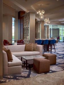a lobby with couches and a table and a bar at The Royal Sonesta Houston Galleria in Houston