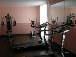 um ginásio com duas bicicletas de exercício e um espelho em Green Hotel em Settimo Torinese