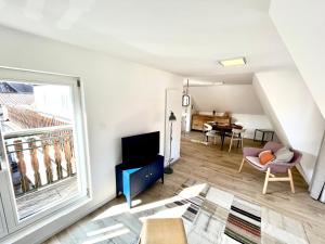 - un salon avec une grande fenêtre et un canapé dans l'établissement Sous les toits avec garage et terrasse à Ribeauville, à Ribeauvillé