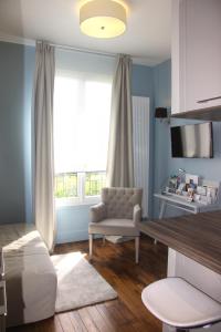 1 dormitorio con ventana, silla y mesa en Côté Marne, en Champigny-sur-Marne