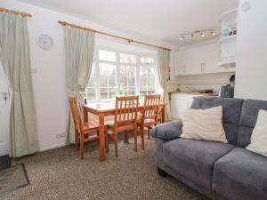 a living room with a table and chairs and a couch at Priory Ghyll in Windermere