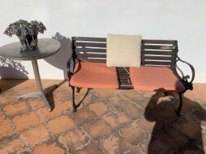 a bench and a table with a vase of flowers at Casa Fraile San Miguel in San Miguel de Allende