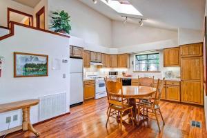 a kitchen with a table and chairs and a kitchen with white appliances at Little Sport in Yosemite West