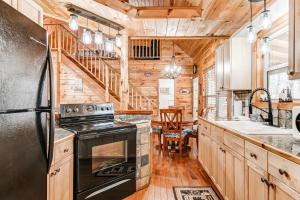 a kitchen with a black refrigerator and wooden cabinets at Wooded Wonder in Cleveland