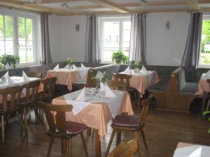 un restaurante con mesas y sillas con flores. en 2 Sterne Pension Gasthof ohne Internet, en Steinbach am Attersee