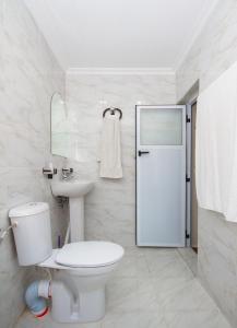 a white bathroom with a toilet and a sink at Hotel Al kassaba in Chefchaouen +65 photos