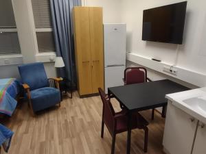 a small room with a table and chairs and a television at Hotel 24 - Karihaara - Kemi in Kemi