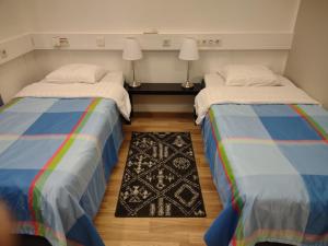 two beds sitting next to each other in a room at Hotel 24 - Karihaara - Kemi in Kemi