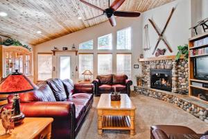 a living room with a leather couch and a fireplace at Serenity Pines in Yosemite West