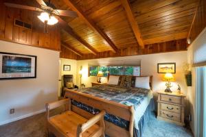 a bedroom with a large bed with a wooden ceiling at Sierra Springs in Oakhurst +23 photos