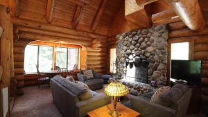 a living room with a stone fireplace in a log cabin at Tioga Logs in Yosemite West