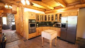 a kitchen with wooden cabinets and a stainless steel refrigerator at Tioga Logs in Yosemite West