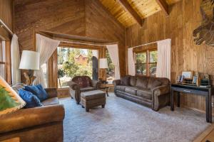a living room with leather furniture in a log cabin at Tree Haven in Yosemite West