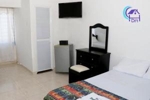 a bedroom with a bed and a mirror and a dresser at HOTEL DOÑA ANA in Mangue
