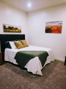 a bedroom with a bed and two paintings on the wall at Sevier River Farmhouse 2 in Hatch