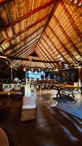Habitación grande con mesas, bancos y techo de madera. en Refugio Monte Oscuro, en Las Mercedes