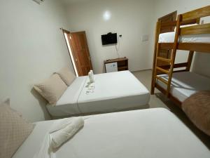 a room with two bunk beds and a television at Pousada Casa da Cion in Jericoacoara