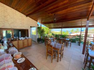 a patio with tables and chairs and a kitchen at Pousada Casa da Cion in Jericoacoara