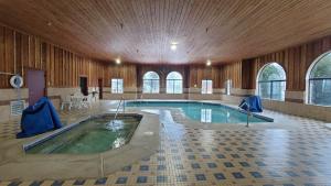 a large swimming pool in a large building with a pool at Bay Inn in Tawas City