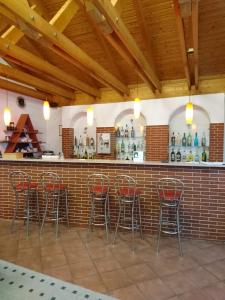 a bar with red stools against a brick wall at Penzion Forest 2 in Rozvadov