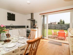 a kitchen and dining room with a table and chairs at The Barn in High Catton