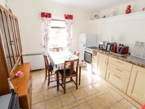 a kitchen with a table and a table and chairs at The Cottage in Carrowsallagh Bridge