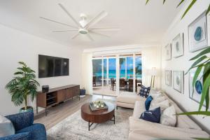 a living room with a couch and a tv at Club Se7en at Beachcomber in Upper Land