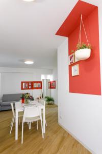 sala de estar con mesa y pared roja en TERRAVERA, en Terrasini