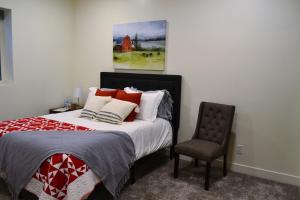 1 dormitorio con 1 cama con silla y 1 pintura en Sevier River Farmhouse 1, en Hatch