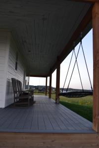 eine Veranda mit Schaukelstuhl auf einem Haus in der Unterkunft Sevier River Farmhouse 1 in Hatch