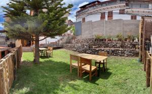 a table and chairs and a tree in a yard at Pampa Wasi in Cusco