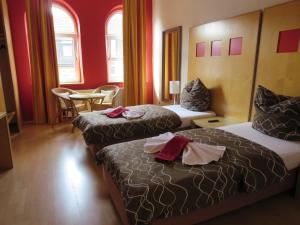 ein Hotelzimmer mit 2 Betten, einem Tisch und Stühlen in der Unterkunft Ruhrzimmer in Gelsenkirchen