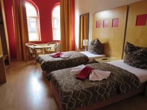 Una habitación de hotel con dos camas y una mesa y sillas. en Ruhrzimmer, en Gelsenkirchen