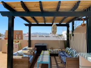 pergola z krzesłami i stołami na patio w obiekcie Atico con piscina privada a 100m del mar w mieście Vera