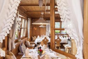 una sala da pranzo con tavoli e sedie bianchi di Hotel die Arlbergerin ADULTS FRIENDLY 4 STAR a Sankt Anton am Arlberg