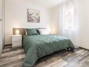 um quarto com uma cama com um edredão verde em Gîte Saint-Philbert-de-Grand-Lieu, 3 pièces, 4 personnes - FR-1-306-980 em Saint-Philbert-de-Grand-Lieu