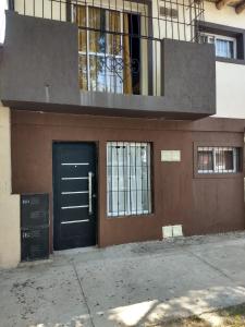 a building with a black door and a balcony at DTOS. MARÍA in Godoy Cruz