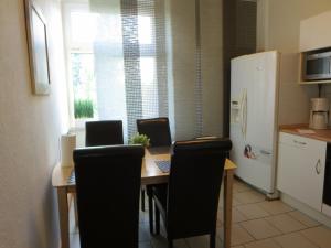 Una cocina con una mesa con sillas y un refrigerador. en Ruhrzimmer, en Gelsenkirchen 12 fotos más