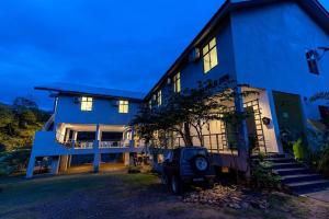 a blue house with a jeep parked in front of it at RIVERSIDE PALM INN SG LEMBING in Sungai Lembing