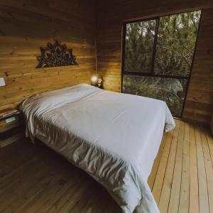 een slaapkamer met een bed in een blokhut bij Cabañas Refugio Himalaya in Guatapé +50 foto's
