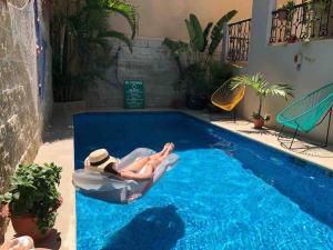 a woman laying in a bath tub in a swimming pool at Suites Fenicia in Playa del Carmen