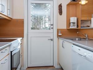 ヘンネ・ストランドにある6 person holiday home in Henneの白いドアとシンク付きのキッチン