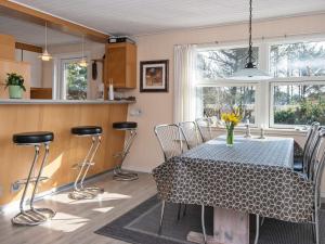 a dining room with a table and chairs and a kitchen at 6 person holiday home in Henne in Henne Strand