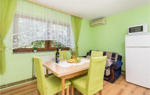 a dining room with a table and yellow chairs at Stunning Apartment In Otocac With Wifi in Otočac